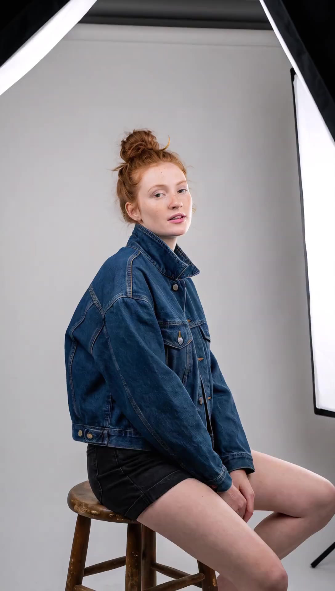 She unbuttons her denim jacket and drops it off her shoulders. ...